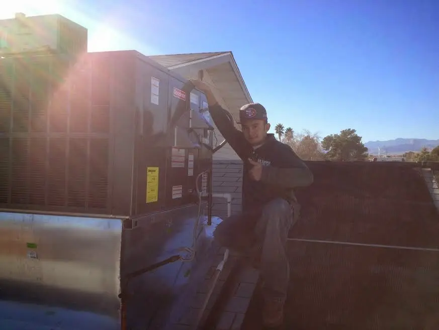 HVAC technician performing Heat Pump Repair on a rooftop unit in Collierville